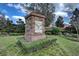 Landscaped Sawgrass Bay community sign with brick and stone base on a sunny day at 3935 Fescue St, Clermont, FL 34714