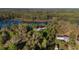 Scenic aerial of the property, with its idyllic lake and surrounded by lush forest at 39615 Forest Dr, Eustis, FL 32736