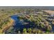 Picturesque aerial view of a lakeside home encircled by lush trees and clear water at 39615 Forest Dr, Eustis, FL 32736