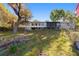 Backyard view of the home, with a spacious lawn and mature trees at 39615 Forest Dr, Eustis, FL 32736