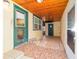 Covered patio with tile floor, wood ceiling and green door leading to the backyard at 39615 Forest Dr, Eustis, FL 32736