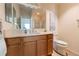 Bathroom featuring wood cabinets, a white quartz countertop, a large mirror, and updated fixtures at 4036 Venetian Ln, The Villages, FL 32163