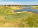 Scenic golf course view with lush green fairways, a tranquil lake, and blue sky at 4036 Venetian Ln, The Villages, FL 32163