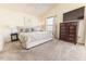 Well-lit main bedroom featuring cozy carpet, a ceiling fan, and a television at 4036 Venetian Ln, The Villages, FL 32163