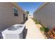 Side yard featuring a concrete walkway, vinyl siding, and an AC unit at 4036 Venetian Ln, The Villages, FL 32163