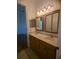 Bathroom with double sink vanity, warm lighting, and decorative framed mirrors at 42316 E Saffron Ct, Eustis, FL 32736