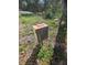 Outdoor electrical box with wiring in the backyard, with grass and tree trunk at 42316 E Saffron Ct, Eustis, FL 32736