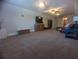 Large room with neutral carpeting, tv, and comfortable seating at 42316 E Saffron Ct, Eustis, FL 32736