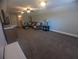 Large Gathering room with neutral carpeting, tv, and comfortable seating at 42316 E Saffron Ct, Eustis, FL 32736