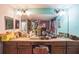 Bathroom featuring dual vanity sinks, large mirrors, and a decorative countertop at 4654 Coppola Dr, Mount Dora, FL 32757