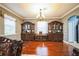 Formal dining room with hardwood floors, crown molding, and elegant wood China cabinets at 4654 Coppola Dr, Mount Dora, FL 32757