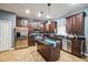 Spacious kitchen featuring an island, dark wood cabinetry, and stainless steel appliances at 4654 Coppola Dr, Mount Dora, FL 32757