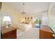 The yellow main bedroom features a chandelier, en-suite bathroom, and private access to patio at 480 Ne 45Th Ter, Ocala, FL 34470