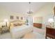 The yellow main bedroom features a chandelier, en-suite bathroom, and lots of natural light at 480 Ne 45Th Ter, Ocala, FL 34470