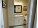 Bathroom featuring white cabinets, granite counters, framed mirror, and warm yellow walls at 511 Van Deen Pl, The Villages, FL 34762