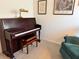 Sitting room featuring a piano, comfortable armchairs, and vintage wall decor at 511 Van Deen Pl, The Villages, FL 34762