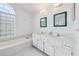 Bathroom vanity area and soaking tub under arched window featuring tiled floors at 5332 Nw 20Th Pl, Ocala, FL 34482