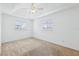 Bedroom features neutral carpet, a ceiling fan, and natural light from windows at 5332 Nw 20Th Pl, Ocala, FL 34482