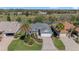 Aerial view of the home and community featuring a golf course, trees, and ponds at 565 Brighton Dr, The Villages, FL 32162