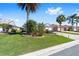 Well-maintained home with a lush lawn and decorative landscaping at 565 Brighton Dr, The Villages, FL 32162