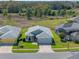 Aerial view of a beautiful home with manicured lawns, a driveway, and mature trees at 5718 Illumination Ln, Leesburg, FL 34748