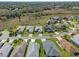 Aerial view of a home with a manicured lawn and landscaping in a well-planned community with mature trees at 5718 Illumination Ln, Leesburg, FL 34748