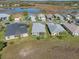 Aerial view of a home with a well-maintained lawn and a large pond in a desirable community at 5718 Illumination Ln, Leesburg, FL 34748