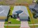 Aerial view of a home with a well-kept lawn, driveway, and defined property lines at 5718 Illumination Ln, Leesburg, FL 34748