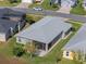 Aerial view of a well-maintained home with a screened lanai and lush green lawn in a quiet neighborhood at 5718 Illumination Ln, Leesburg, FL 34748