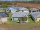 Backyard aerial showcasing a meticulously kept lawn backing up to a scenic pond in a serene neighborhood setting at 5718 Illumination Ln, Leesburg, FL 34748