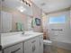 Bright bathroom featuring a white vanity, shower-tub combo and large mirror at 5718 Illumination Ln, Leesburg, FL 34748