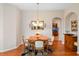 Intimate dining room showcasing hardwood floors, elegant lighting, and an open view of the hallway at 5718 Illumination Ln, Leesburg, FL 34748