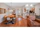 Cozy dining room showcasing hardwood floors, elegant lighting, and an open view of the living area at 5718 Illumination Ln, Leesburg, FL 34748