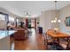 Sunlit living room and dining area, featuring an open floor plan and wood flooring throughout at 5718 Illumination Ln, Leesburg, FL 34748