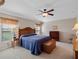 Comfortable main bedroom with soft lighting, a ceiling fan, and neutral decor at 5718 Illumination Ln, Leesburg, FL 34748