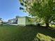 A lovely home, showcasing an enclosed porch and a well-manicured lawn, framed by mature trees at 607 Webb Way, The Villages, FL 32159