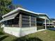 Side exterior of a single story home with a screened-in room and green lawn at 607 Webb Way, The Villages, FL 32159