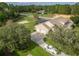 Aerial view of a home with three-car garage, long driveway, and fenced backyard at 6206 Ocilla Loop, Clermont, FL 34714