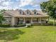 Welcoming single Gathering home featuring dormer windows, lush landscaping, and a covered front porch at 6206 Ocilla Loop, Clermont, FL 34714