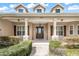 Inviting front porch with stone supports, manicured landscaping, and a welcoming entrance at 6206 Ocilla Loop, Clermont, FL 34714