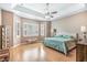 Tranquil main bedroom with tray ceiling, shuttered windows, and hardwood floors at 6206 Ocilla Loop, Clermont, FL 34714