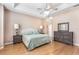 This main bedroom offers a ceiling fan, wooden floors, and dresser with mirror at 6206 Ocilla Loop, Clermont, FL 34714