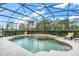 Inviting screened-in pool and spa with comfortable lounge chairs and serene landscaping, perfect for relaxation at 6206 Ocilla Loop, Clermont, FL 34714