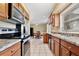 Galley kitchen boasts wood cabinets, stainless steel appliances, and a view into the dining area at 7036 Clarcona Ocoee Dr, Orlando, FL 32818