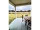 View of the covered back patio with table and chairs and a view of the field at 726 Eagle Landing Blvd, Winter Haven, FL 33880