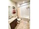 Well-lit bathroom with a tiled floor, bathtub with shower, commode, and sink with vanity at 726 Eagle Landing Blvd, Winter Haven, FL 33880