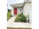 Home exterior showcasing a red front door and small garden at 726 Eagle Landing Blvd, Winter Haven, FL 33880