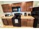 Functional kitchen with dark cabinetry, stainless steel appliances, and tile flooring at 726 Eagle Landing Blvd, Winter Haven, FL 33880