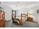 Spacious bedroom featuring a ceiling fan, carpet floors, and a charming, wooden four-poster bed at 8425 Se 177Th Bartram Loop, The Villages, FL 32162