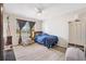 Bright bedroom featuring a ceiling fan, carpet floors, and a window with decorative curtains at 8425 Se 177Th Bartram Loop, The Villages, FL 32162